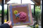 Pink elephant with yellow flower
